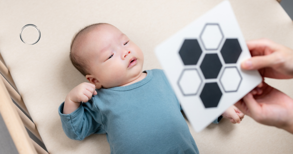 bebê olhando para cartão de alto contraste em formato hexagonal