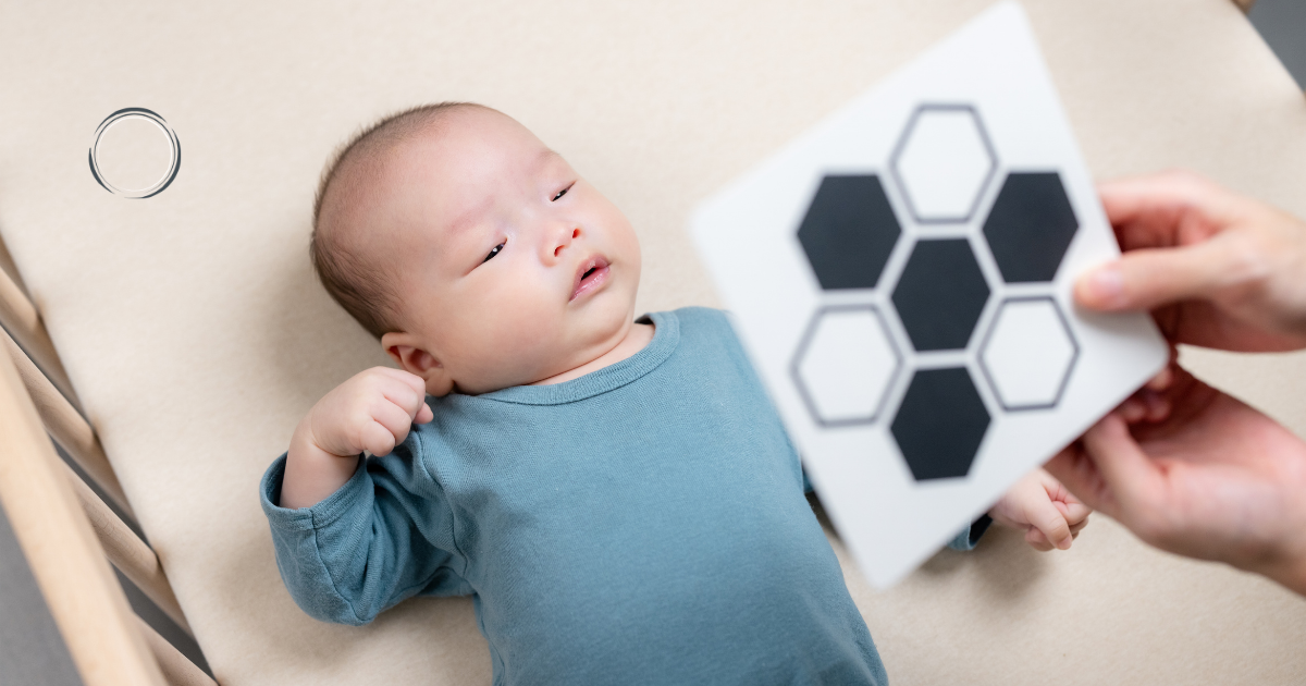 bebê olhando para cartão de alto contraste em formato hexagonal