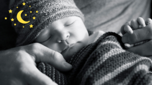 bebê com gorro dormindo no colo