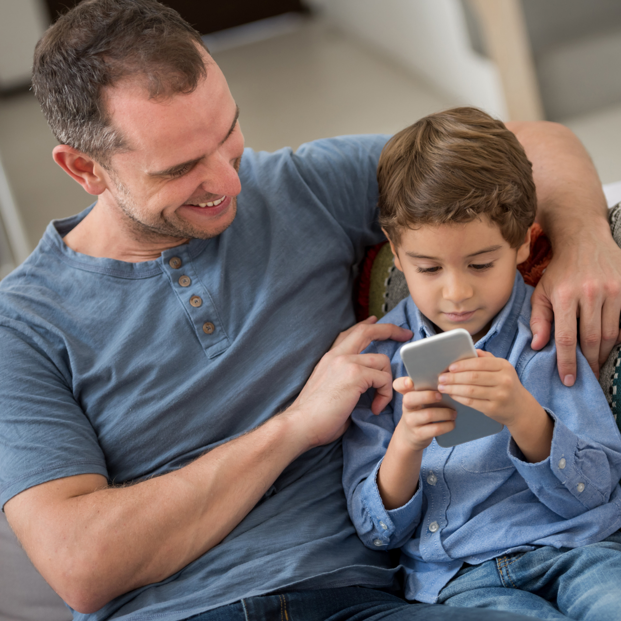 Pai e filho jogando juntos em jogo educativo no celular