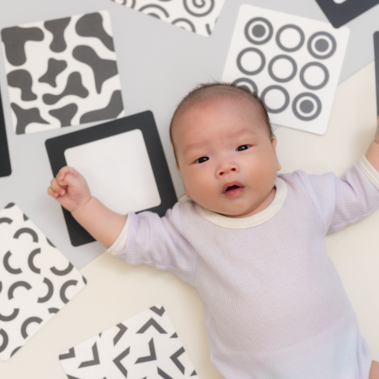 Bebê olhando atentamente para cartão de alto contraste em preto e branco