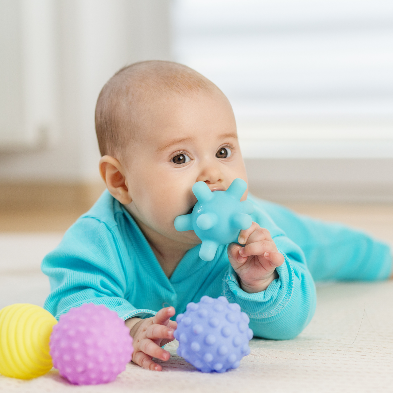 Bebê brincando com objetos coloridos e texturas diferentes durante estimulação sensorial