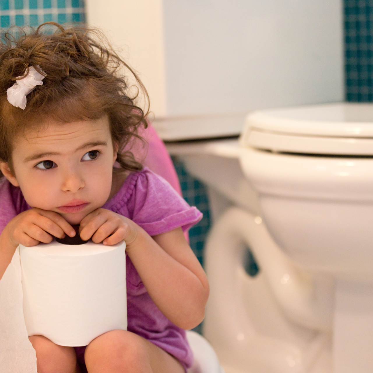 Menina sentada no vaso sanitário, ilustrando rotina de banheiro na infância