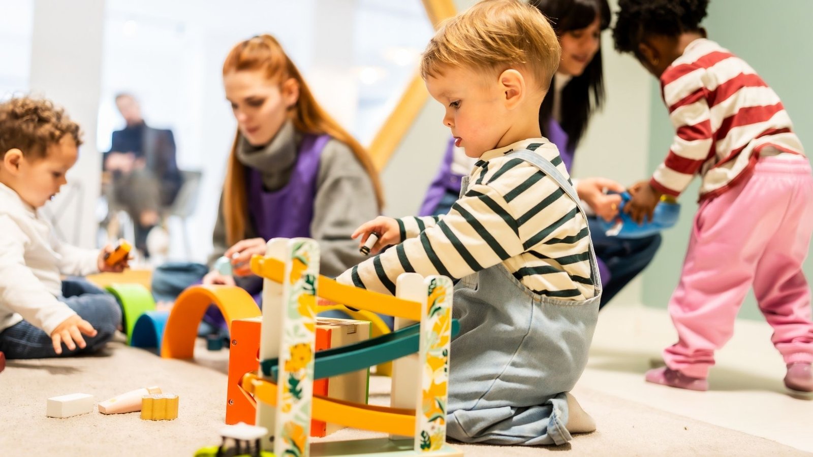 Crianças do maternal brincando em grupo com brinquedo de rampa