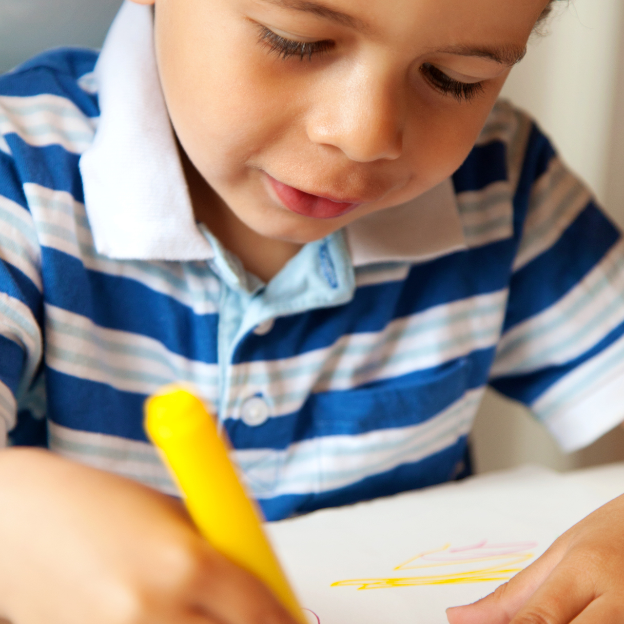 Criança pequena colorindo com giz de cera