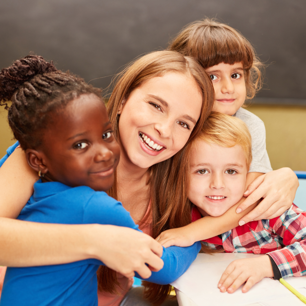 Professora abraçada com alunos de educação infantil