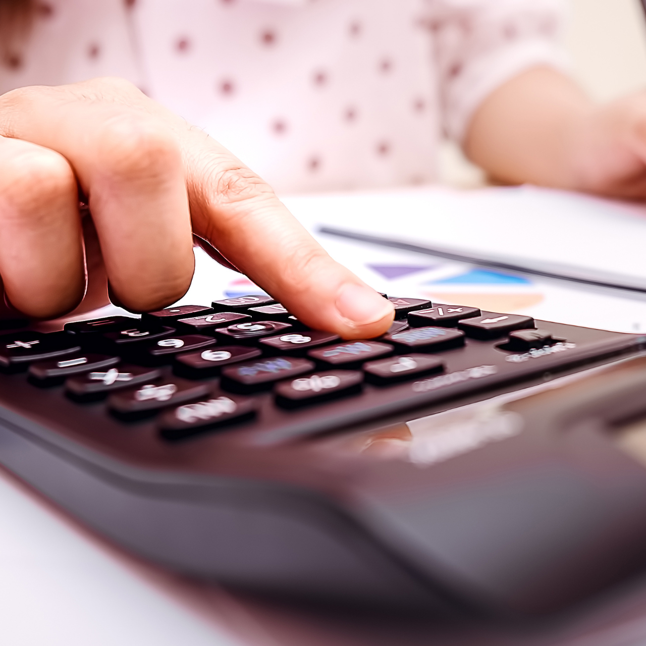 Pessoa calculando o orçamento familiar com calculadora e gráficos