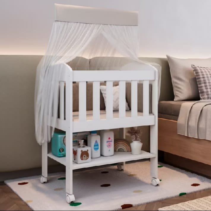 Mini berço branco com grades, rodinhas, prateleira embaixo e dossel de tule