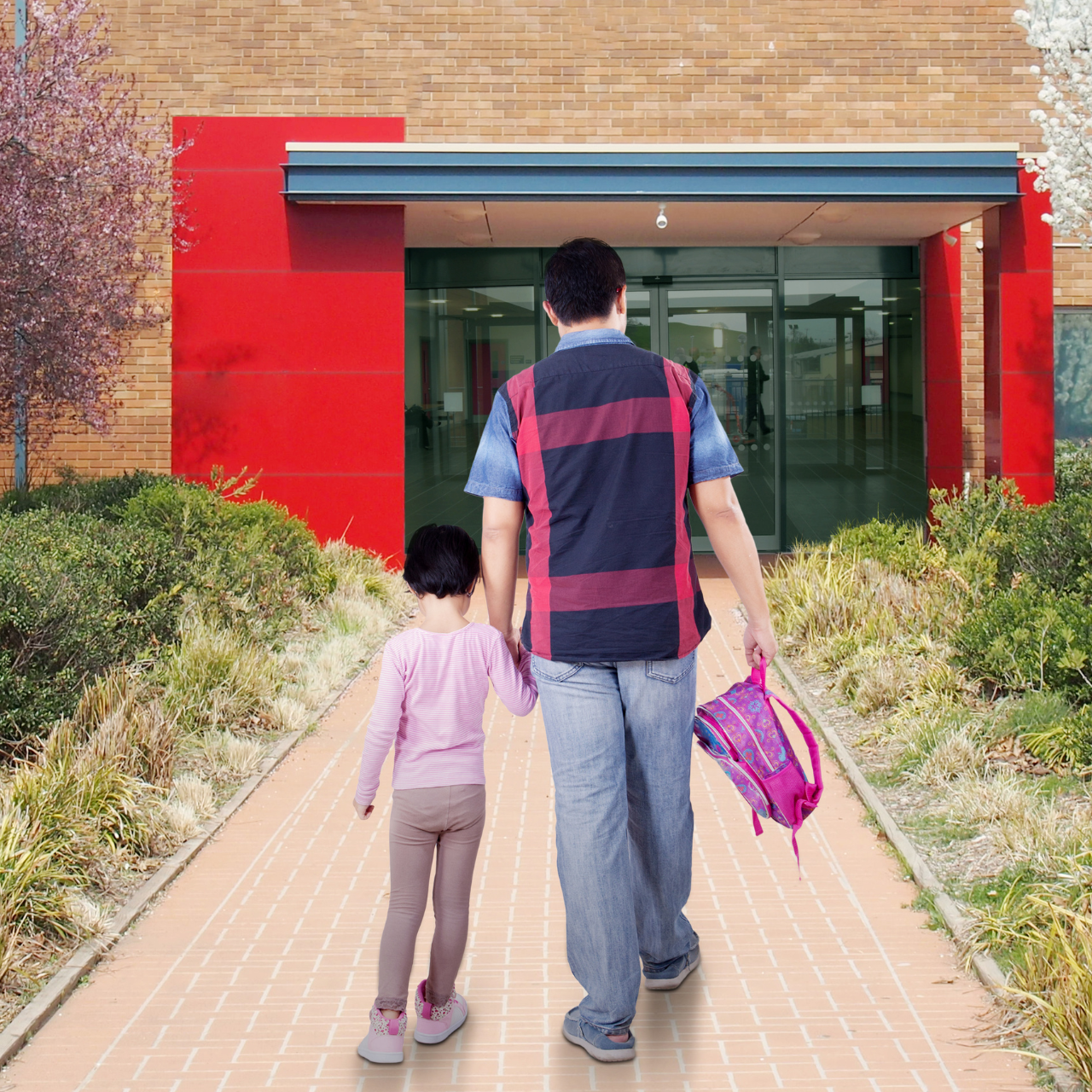 Pai levando a filha pela mão até a entrada da escola