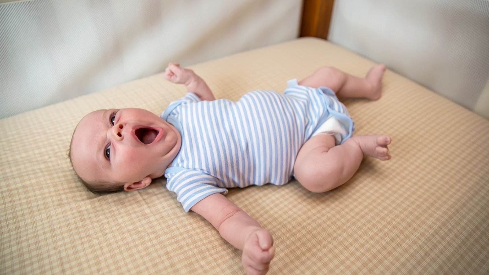 Bebê acordando no berço à noite, se espreguiçando