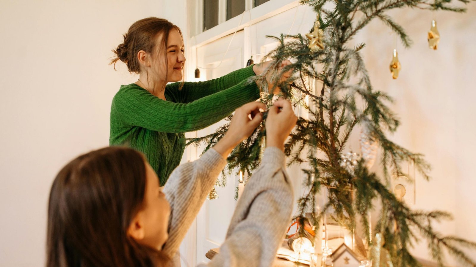 Professora e aluna montando a árvore de Natal da sala de aula